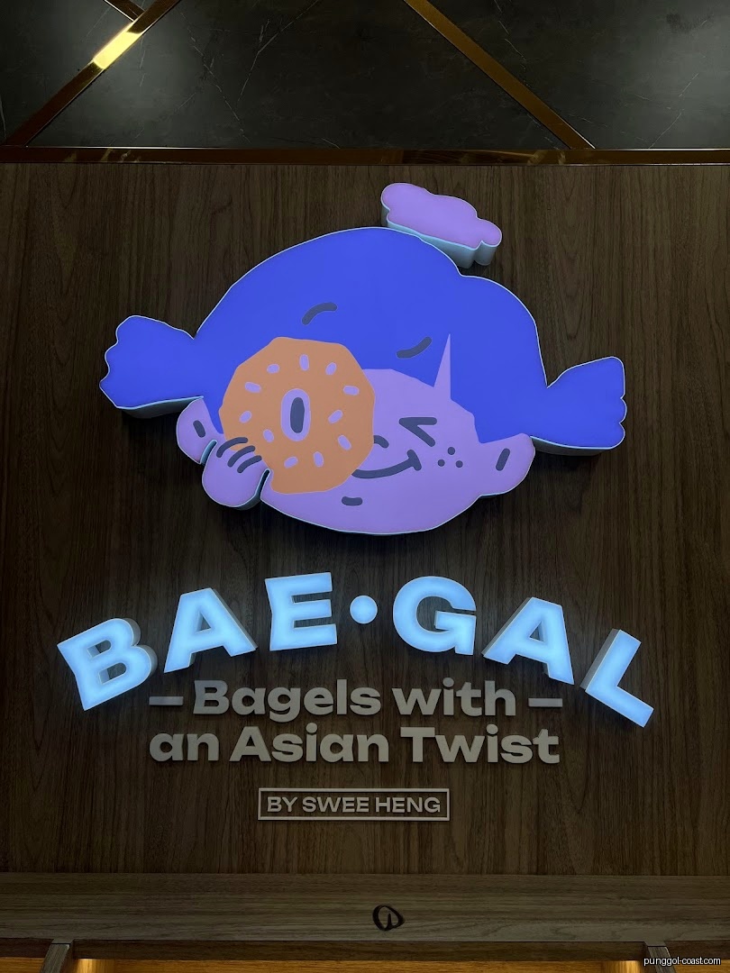 A colorful sign for 'BAE-GAL' bagels with a cartoon character.