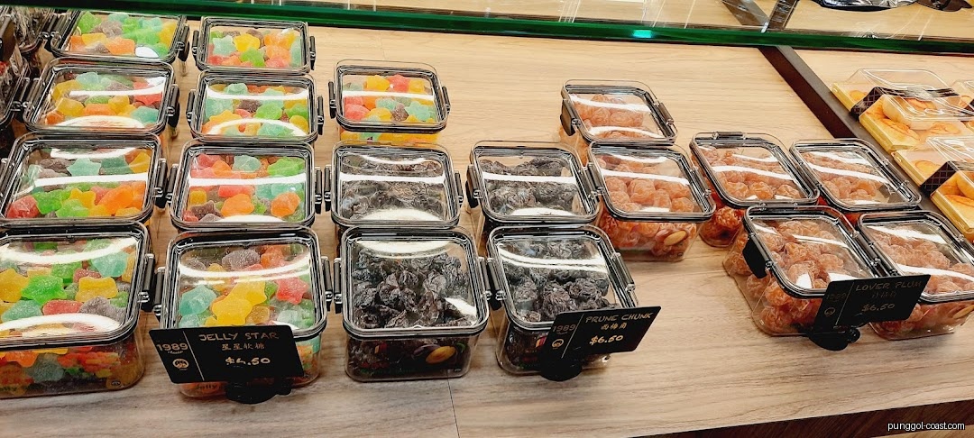 Assorted candies and dried fruits in clear containers on a shop display.