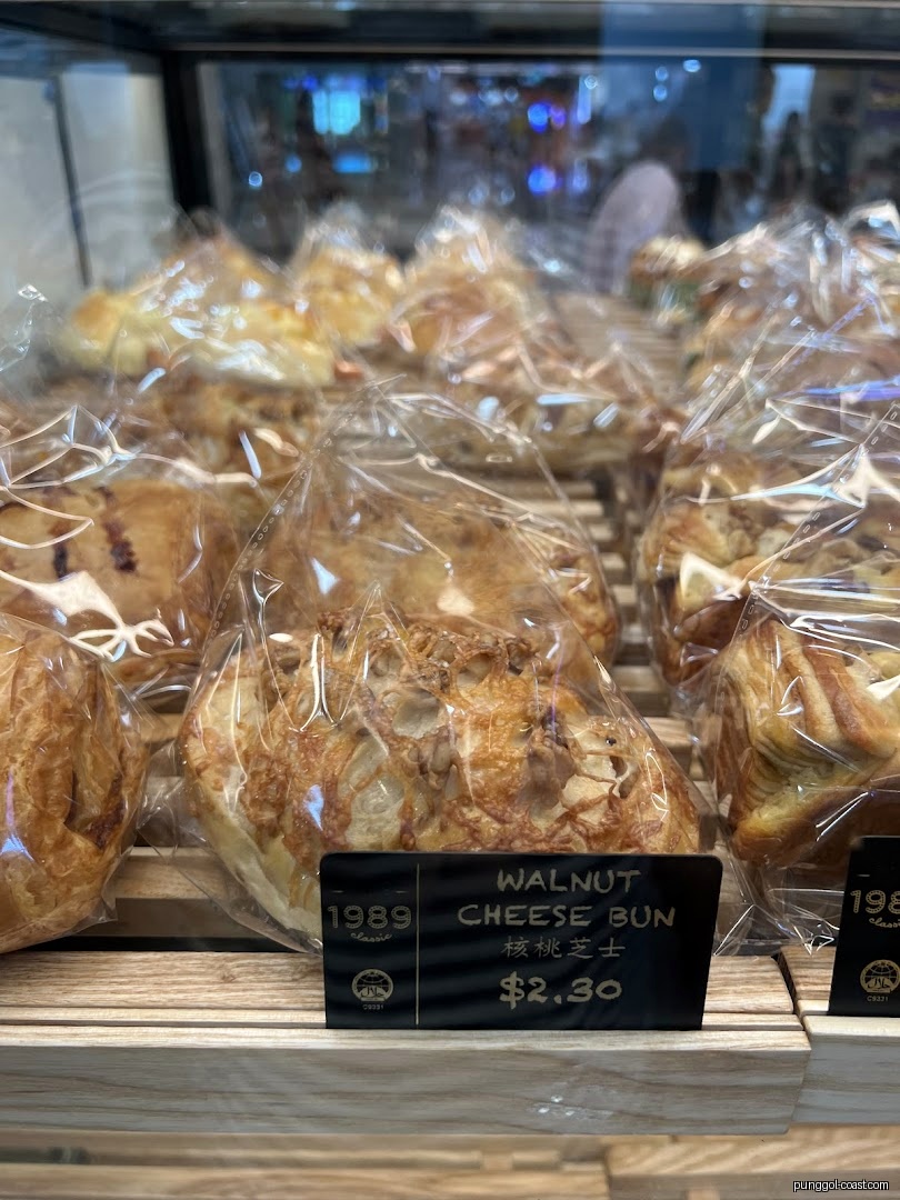 Packaged buns displayed in a bakery case with a price tag.