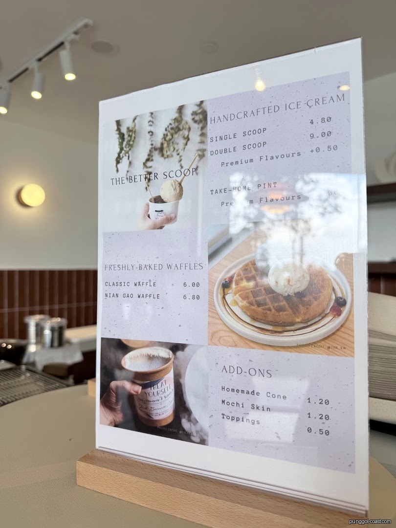 A close-up of a shop's menu displaying ice cream and waffle options.