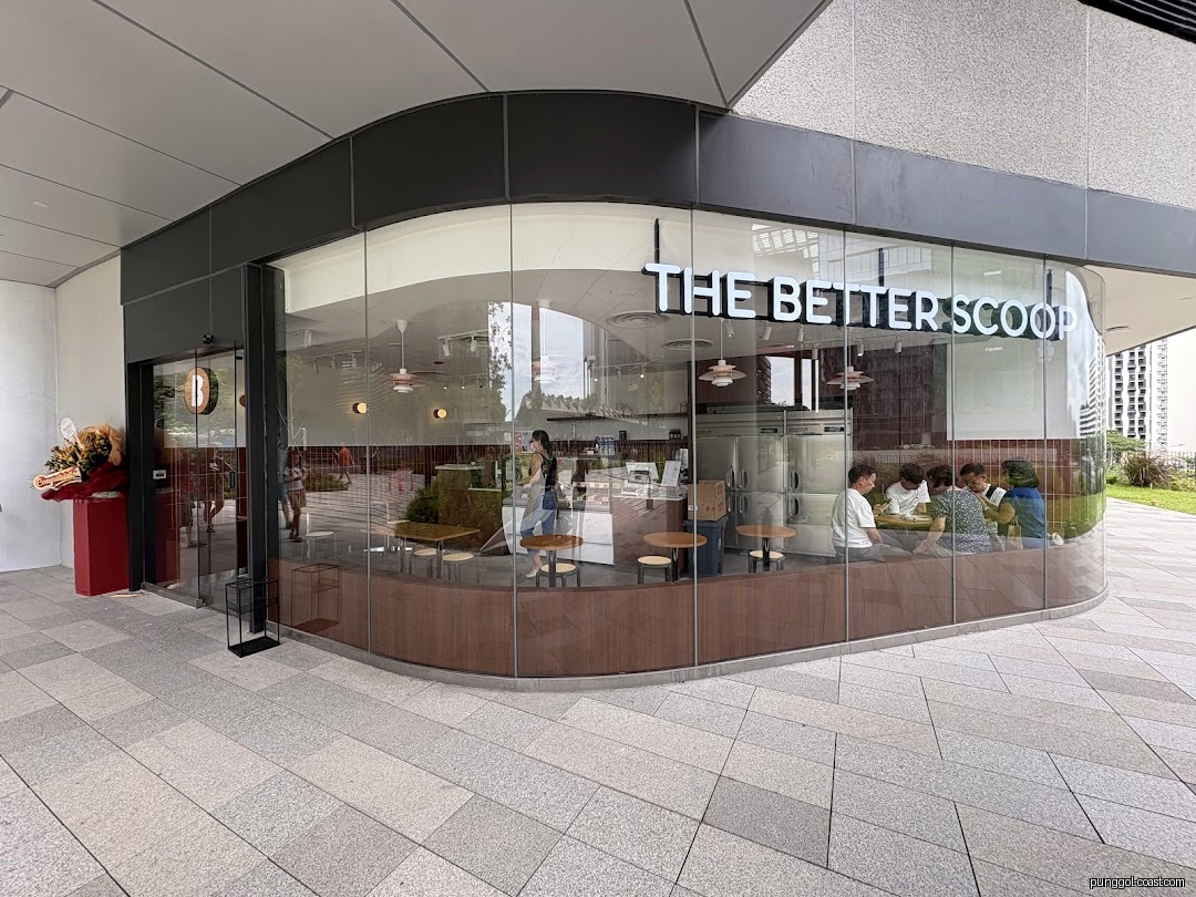 Exterior view of 'The Better Scoop' shop with large windows and people inside.