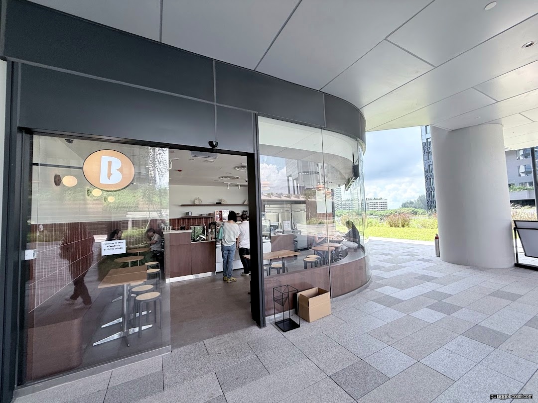Exterior view of 'The Better Scoop' shop with glass entrance and people inside.