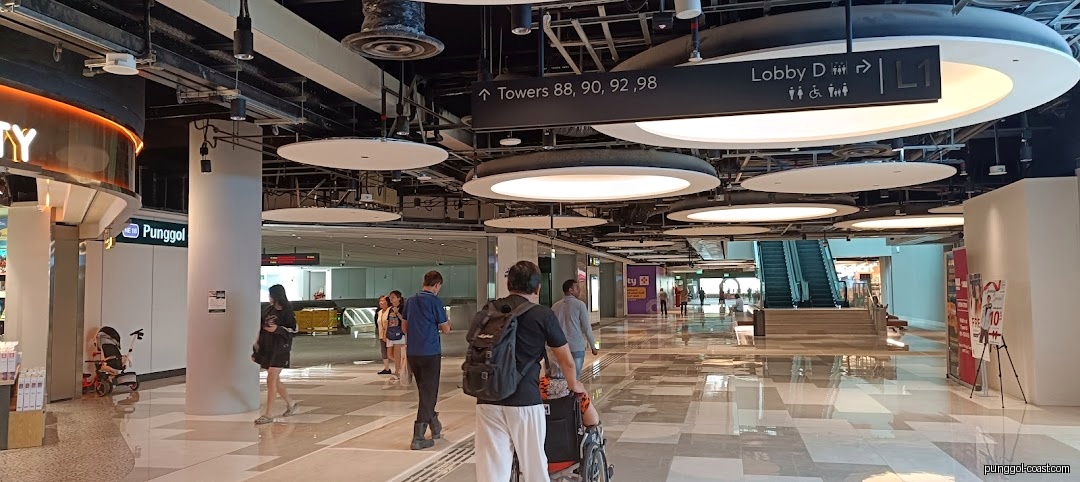 Spacious modern mall interior with people walking and directional signs.