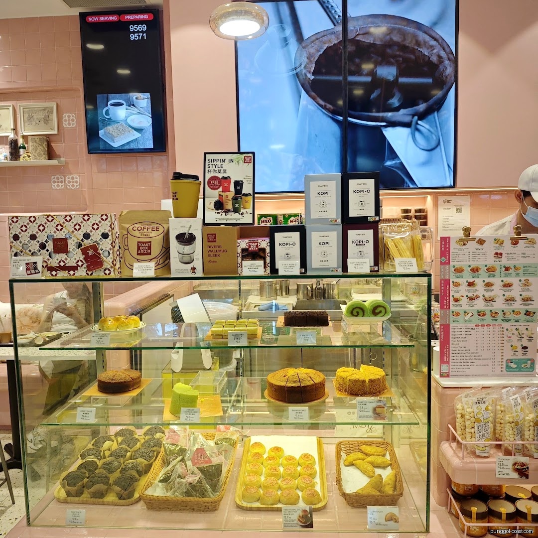 Toast Box interior with a display case of cakes, pastries, and coffee products.