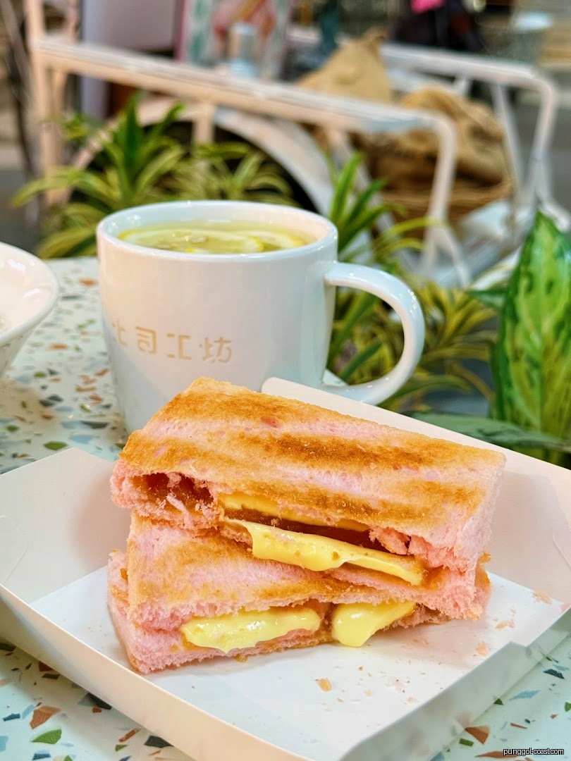 Pink toast with filling and a cup of tea on a patterned table.