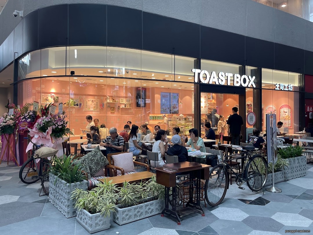Toast Box shop front with outdoor seating area and customers.