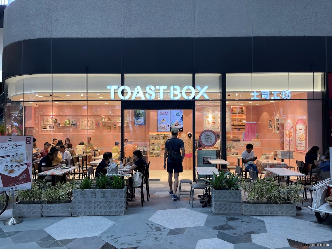 Toast Box shop front with customers and outdoor seating area.