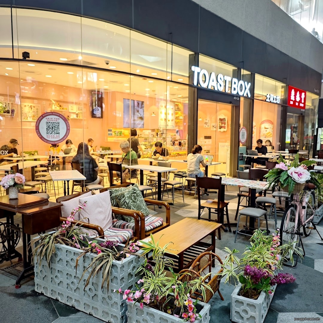 Toast Box shop front with outdoor seating and customers inside.