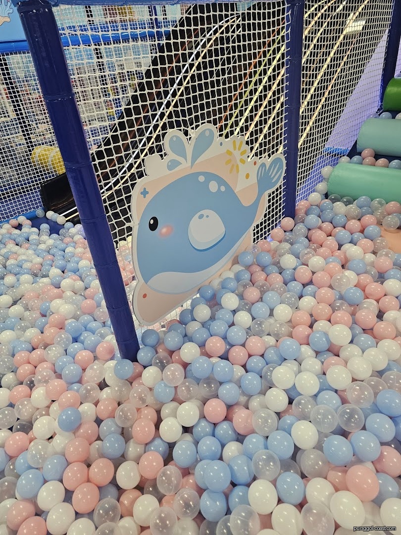 A colorful ball pit with a whale cutout in an indoor play area.