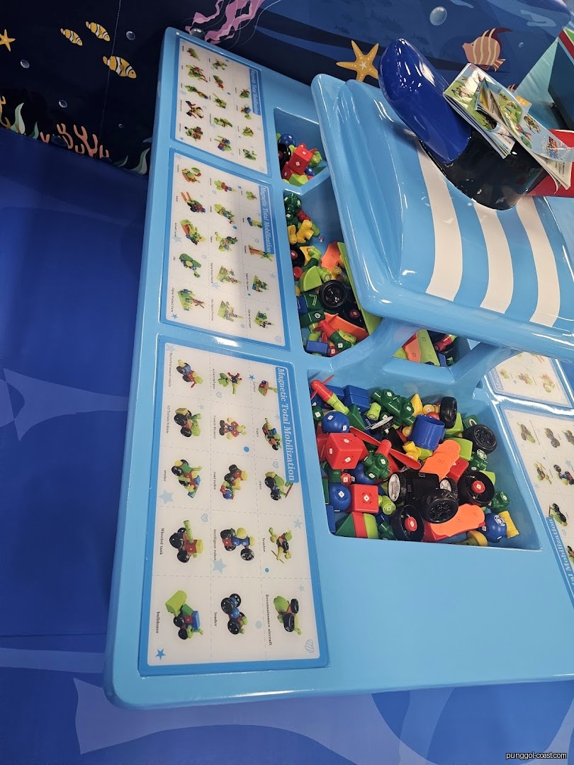 A blue display table filled with colorful building blocks and instructional cards.