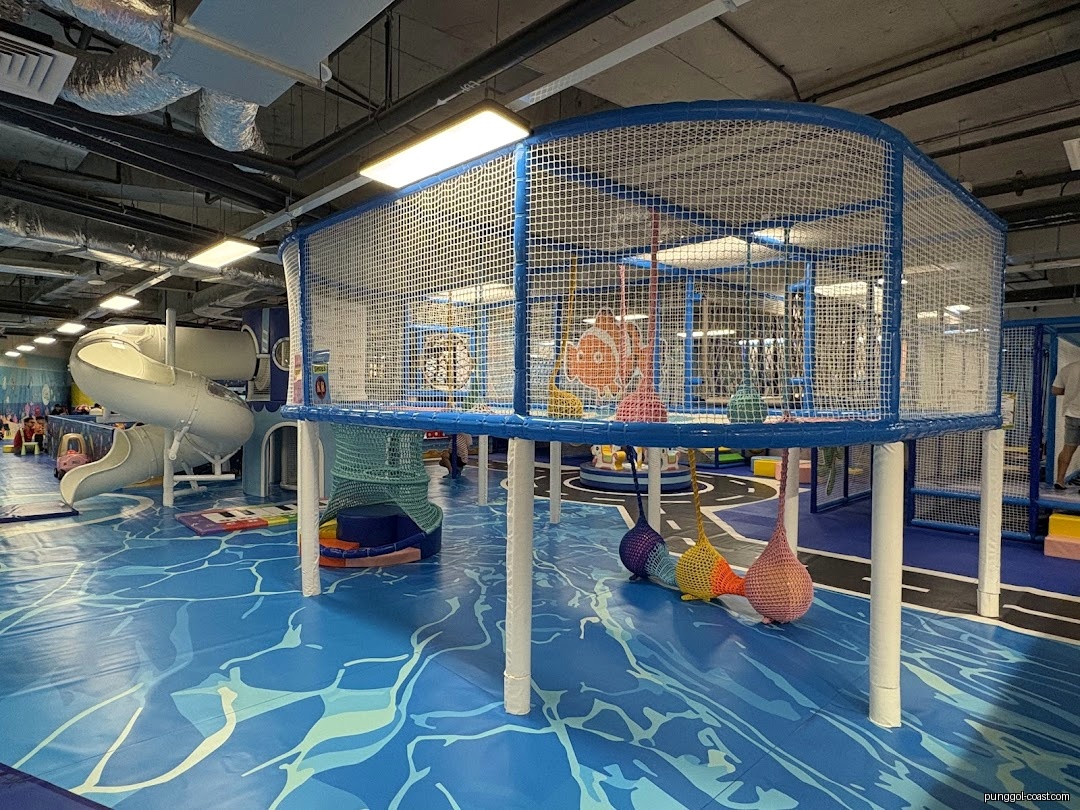 Indoor play area with slides and climbing structures, featuring an ocean theme.