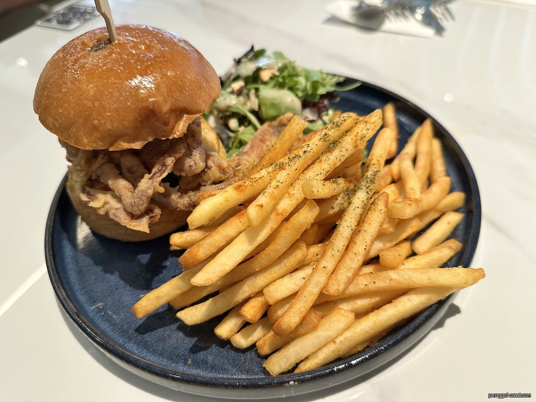 A burger and fries with a side salad on a dark blue plate.