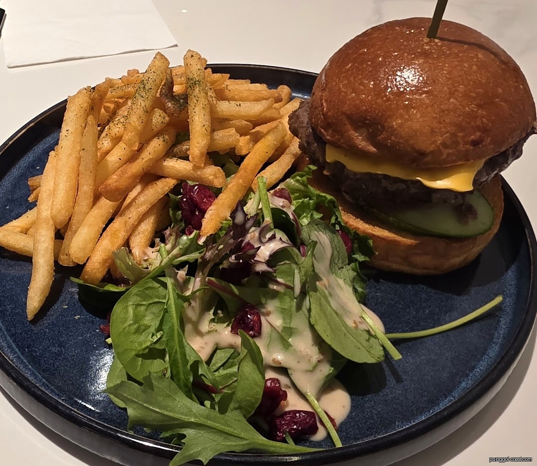 A plate with a burger, french fries, and a side salad.