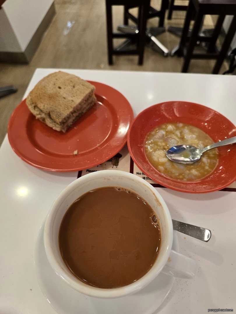 A breakfast set with toast, eggs, and coffee/tea on a white table.