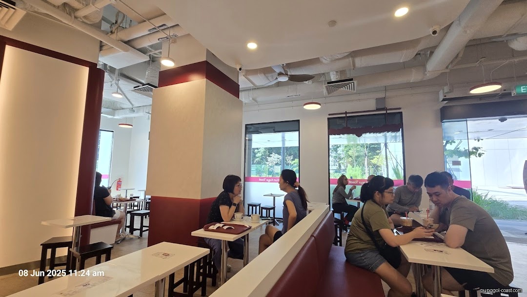 Customers seated inside a brightly lit cafe with large windows.