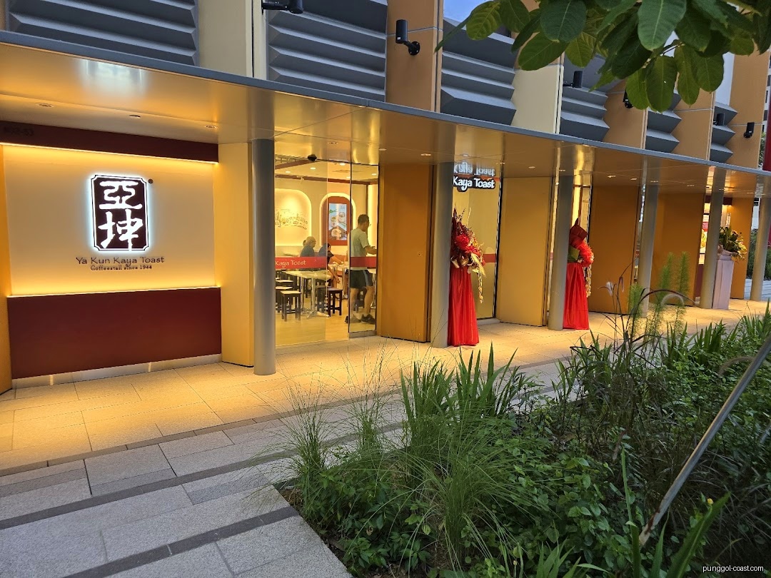 Exterior view of Ya Kun Kaya Toast shop with illuminated sign and entrance.