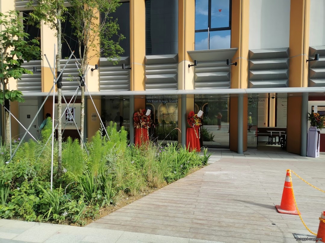 Exterior view of Ya Kun Kaya Toast shop entrance with plants and walkway.