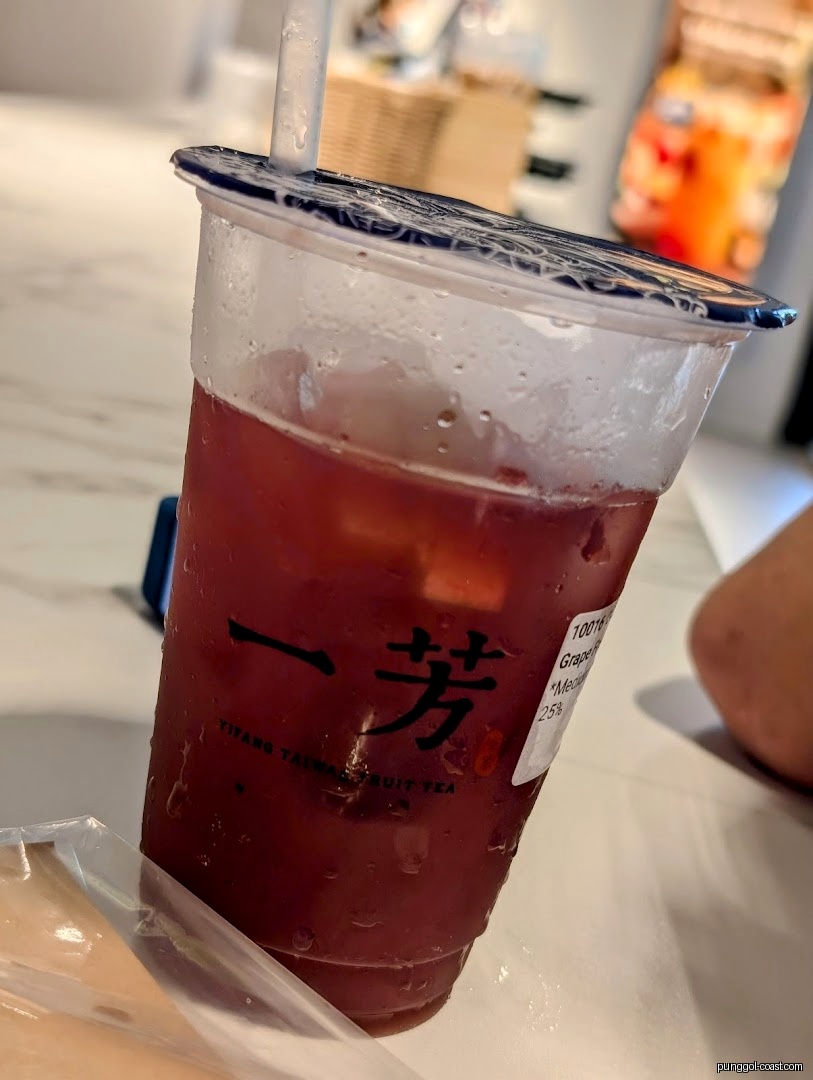 Close-up of a cold grape fruit tea drink with condensation on the cup.