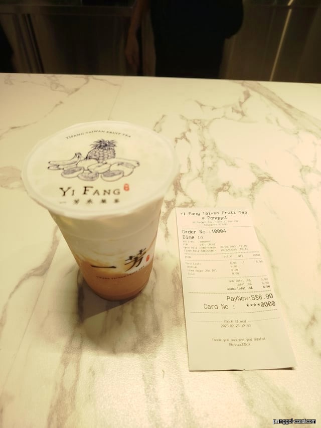 A Yi Fang Taiwan Fruit Tea drink and receipt on a marble table.