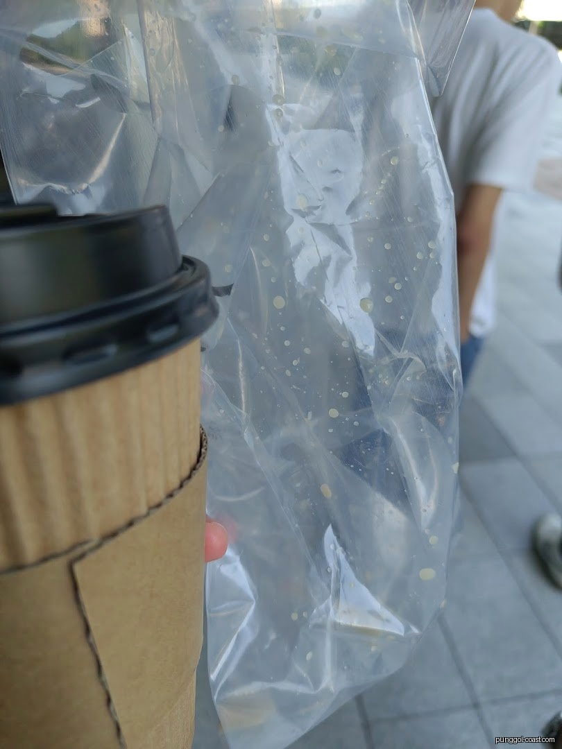 Close-up of a brown paper cup and a plastic bag with liquid.