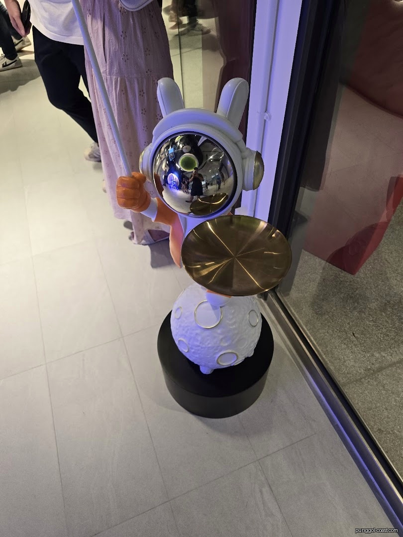 A decorative rabbit statue with a reflective helmet and moon base.