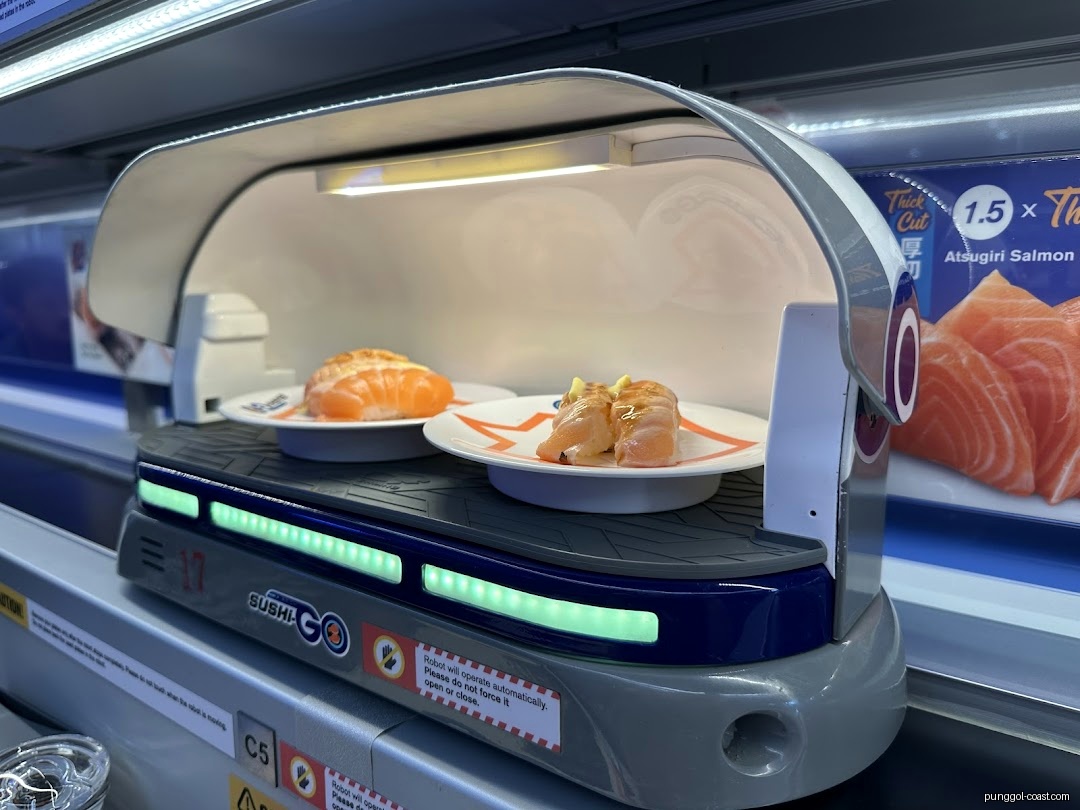 Two sushi plates on a robotic delivery system in a restaurant.