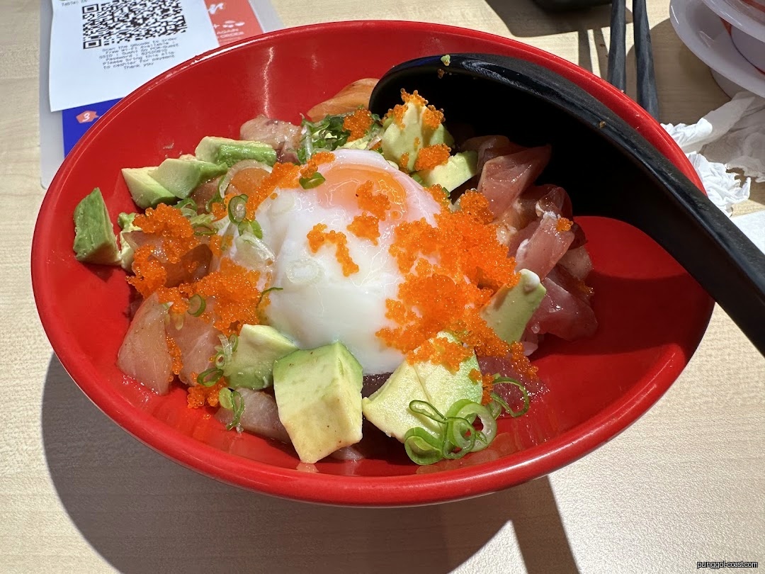 A red bowl filled with poke, avocado, roe, and a poached egg.