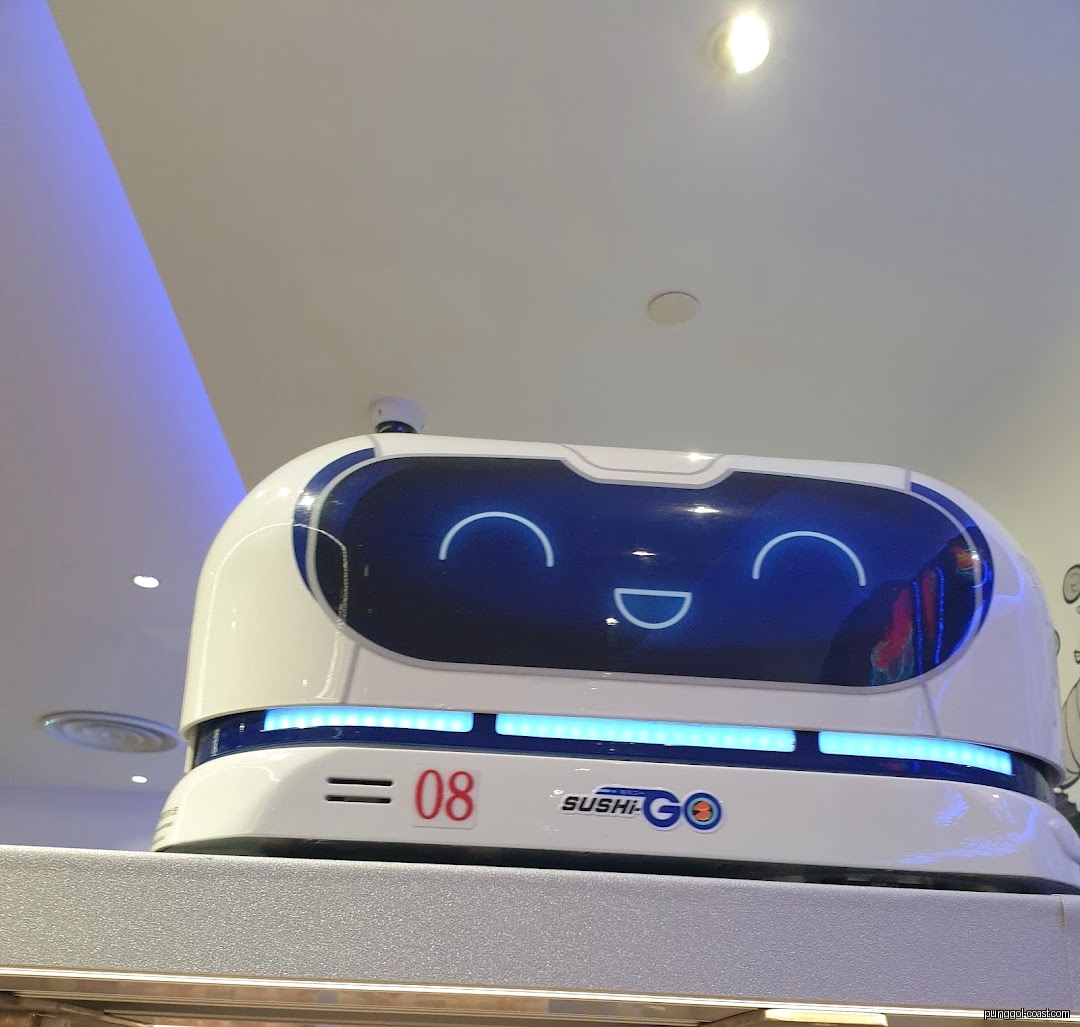 A white delivery robot with a smiling face and Sushi-GO logo.