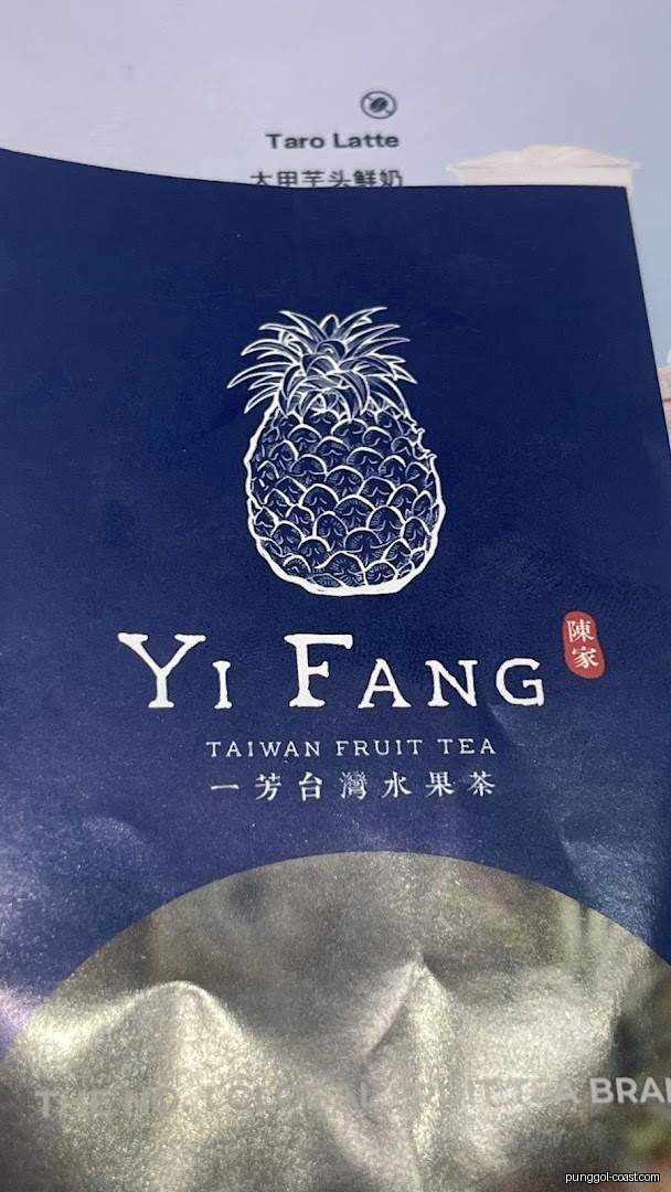 Close-up of Yi Fang Taiwan Fruit Tea menu with pineapple logo and Taro Latte.