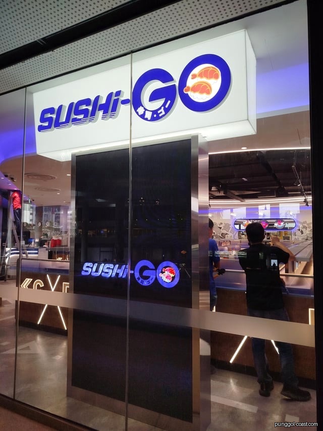 Glass entrance of Sushi-GO shop with signage and interior view.